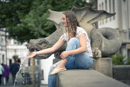 Junge Frau am Brunnen in der Stadt