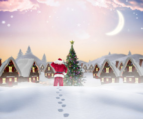 Fototapeta premium Santa walking in the snow against cute christmas village with tree