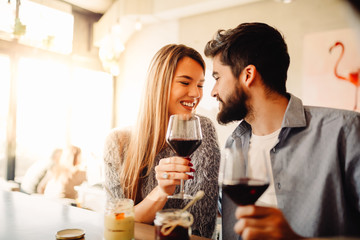 Young couple celebrating their anniversary in cafe with glasses of wine