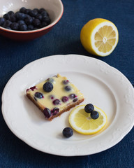 Lemon bars shortbread crumbly crust blue jeans background.