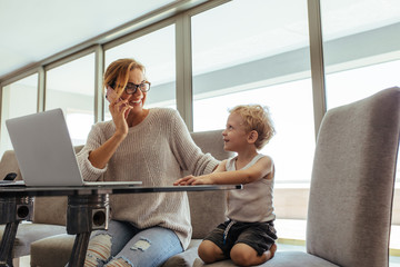 Woman with son working in home office