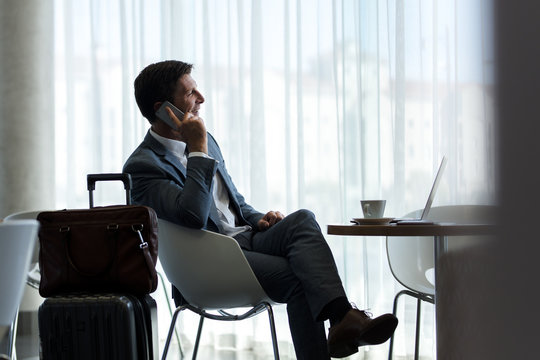 Businessman at airport lounge talking on phone