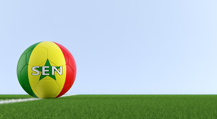 Soccer ball in Senegals national colors on a soccer field. Copy space on the right side - 3D Rendering 