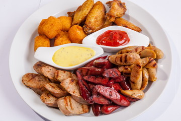 Grilled sausages on a plate with sauce