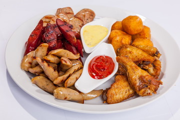 Grilled sausages on a plate with sauce