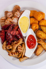 Grilled sausages on a plate with sauce