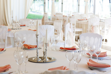 Подсвечники со свечами стоят на сервированном столе в день свадьбы