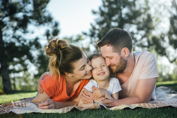 Family with dauhter  rest in park.