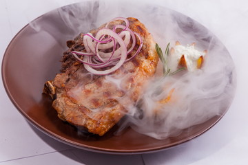 Steak on brown plate with smoke