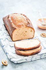 Caramel banana loaf cake on light concrete background. Selective focus, space for text.