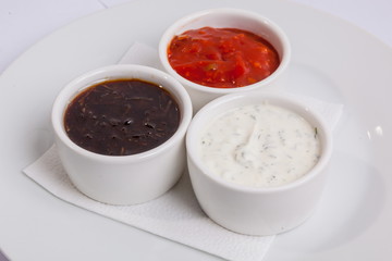 Grilled sausages on a plate with sauce