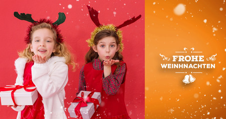 Festive little girls holding gifts against orange vignette