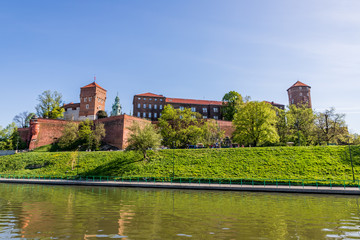 Fototapeta na wymiar Le château du Wawel à Cracovie depuis un bateau sur Le Vistule