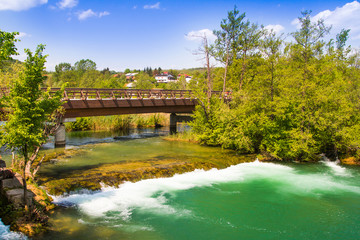 Fototapeta na wymiar Countryside landscape, waterfall and wooden bridge on Mreznica river in Belavici, Croatia 
