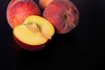Peaches on black background. Top view, copy space