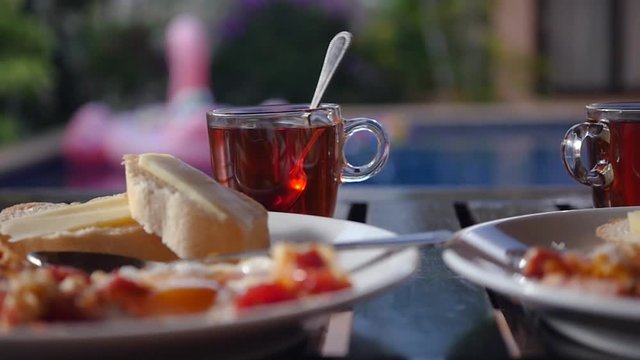 Delicious bright tomorrow from eggs and toast and strong tea on the background of the pool. slow motion, 1920x1080, full hd