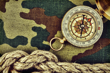 Compass and rope on a camouflage background
