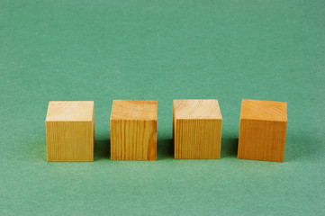 wooden geometric cube on a green background