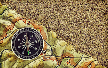 Obraz na płótnie Canvas Old compass on the map with sand