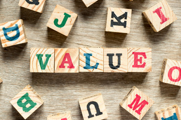 Letter block in word value with another on wood background