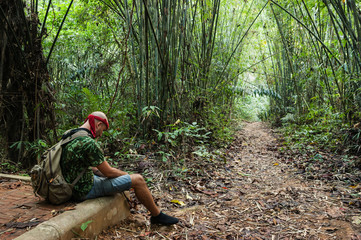 Naklejka na ściany i meble Travelling man sitting in the bamboo forest