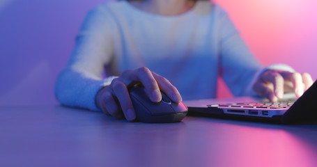 Woman Using notebook computer with blue and purple light
