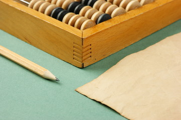 old abacus and notebook on the green background