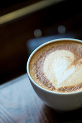 A cup of Cappuccino coffee put on wooden table