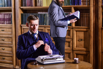 Men in suits in library with antique books with bookshelves