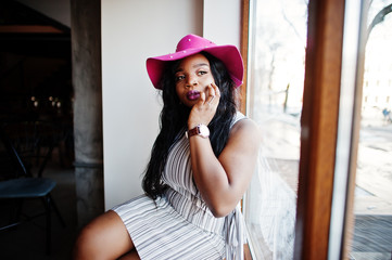 African american woman in hat against window at cafe.