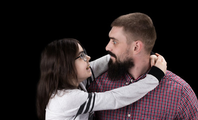 happy father and daughter hugging on black background