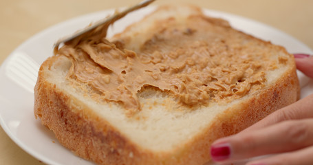 Applying peanut butter on bread