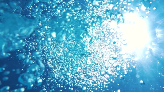 Sunlight passes through water column. Air bubbles rise to surface of water. Sea. Underwater video shooting. Undersea world.