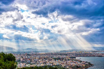 Sunbeams shining through the dramatic clouds over the city Chania. Toned