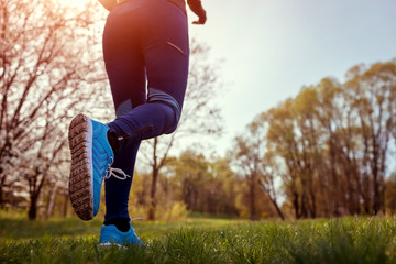 Woman running in spring forest. Close-up of sneakers. Helathy lifestyle concept. Active sportive...
