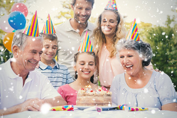 Cheerful extended family celebrating a birthday against snow falling
