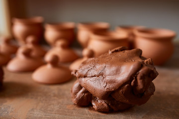 Large piece of red clay closeup on worktop at the potter workshop, close-up, shallow depth of field