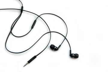 Black headphones for listening to music and sound on portable devices: music player, smartphone, laptop and jack for connection on a white background. Ear plugs.