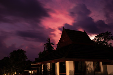 A beach bungalow at night in front of a dramatic sky with an incoming thunder storm during rainy season at the Koh Phi Phi The Beach resort on Koh Phi Phi island along the Andaman coast of Thailand.
