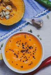 Homemade vegetable soup with pumpkin with cream and black sesame, top view