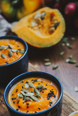Homemade vegetable soup with pumpkin with cream and black sesame, top view with copy space