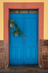 Blue front door at a yellow house