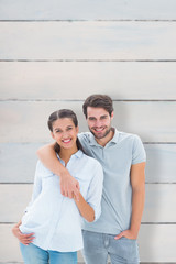 Cute couple smiling at camera against wooden planks