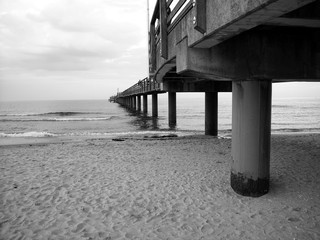 Blick vom Strand auf die Seebrücke Binz mit grauen Wolken an der Binzer Bucht auf der Insel Rügen an der Ostsee in Mecklenburg-Vorpommern, fotografiert in neorealistischem Schwarzweiß