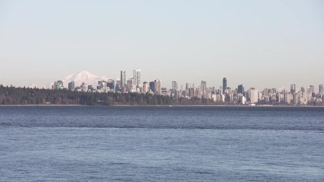 Vancouver Skyline across English Bay 4K UHD. The Vancouver skyline across English Bay. Mount Baker in the background. British Columbia, Canada. 4K. UHD.
