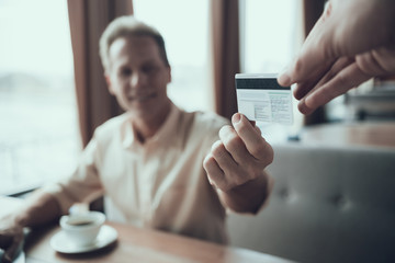 Close up. Adult confident man pays for lunch at restaurant.