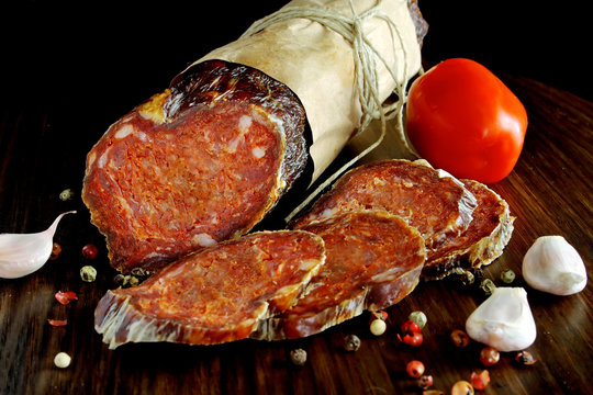 Croatian spicy sausage on wooden board. Kulen.
