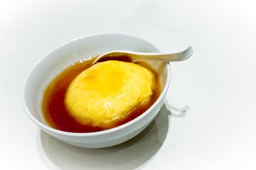 Tenshinhan or Tenshindon/crab omelet on rice in white bowl on white background with copy space. Tenshindon is a Japanese-Chinese specialty, consisting of a crab meat omelette on rice.