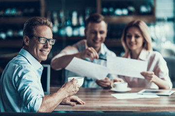Confident businessman drinks coffee during business lunch.