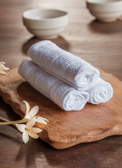 Fototapeta na wymiar Rolled up white spa towels, selective focus, vintage
